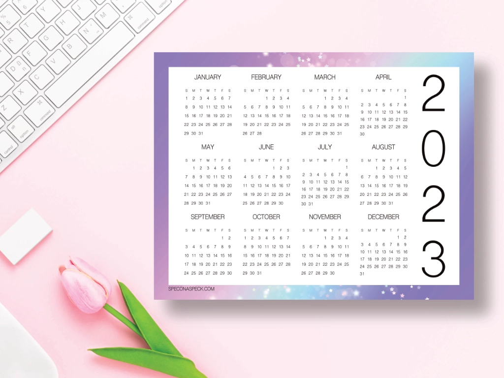 calendar with all the months on one page laying on a pink desk
