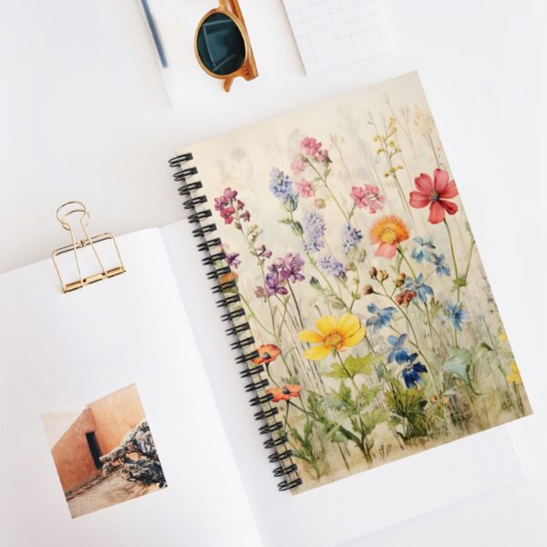 a wildflower spiral notebook with other various objects on a table