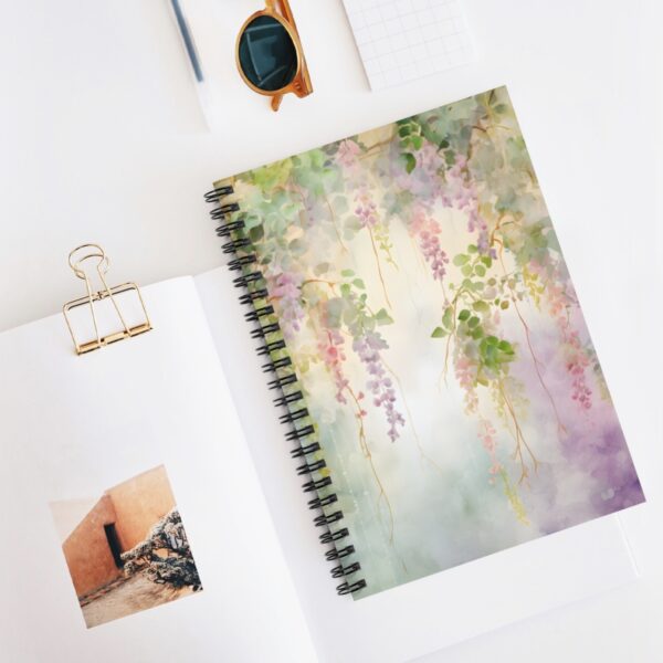 a vine floral cover on a spiral notebook with other various desk supplies